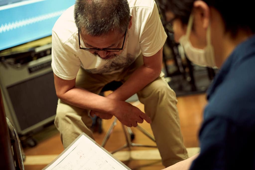 大田家の半地下スタジオでレコーディング中。コード進行の確認をしてる。